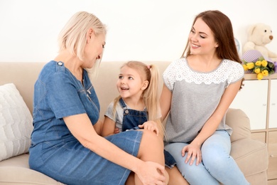 Happy young woman with her mother and daughter at home