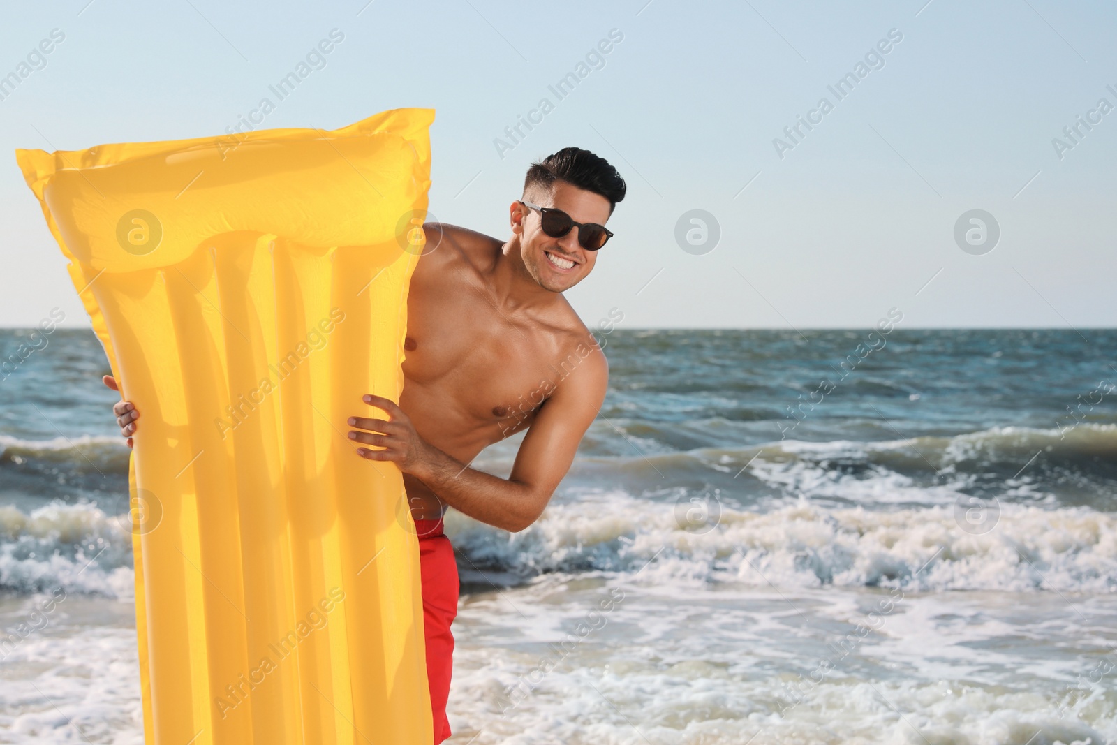 Photo of Man with yellow inflatable mattress at beach