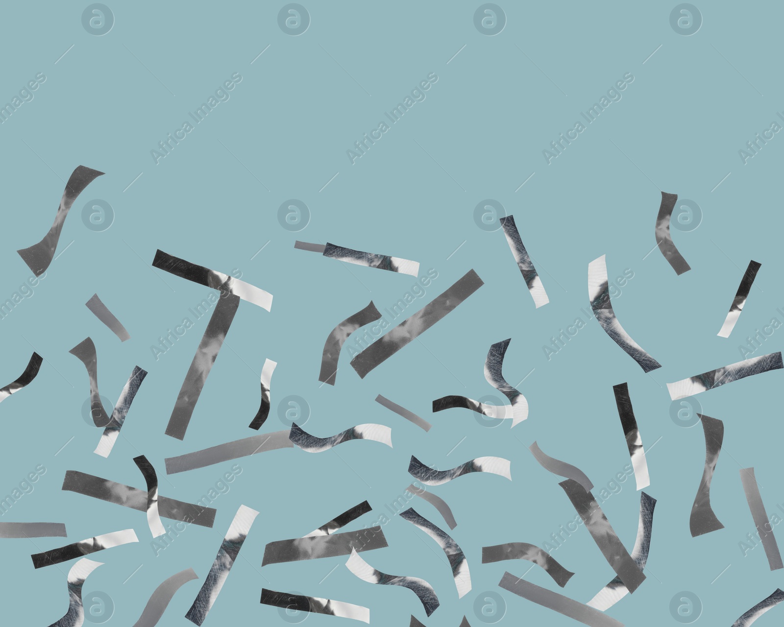 Image of Shiny silver confetti falling on dusty light blue background