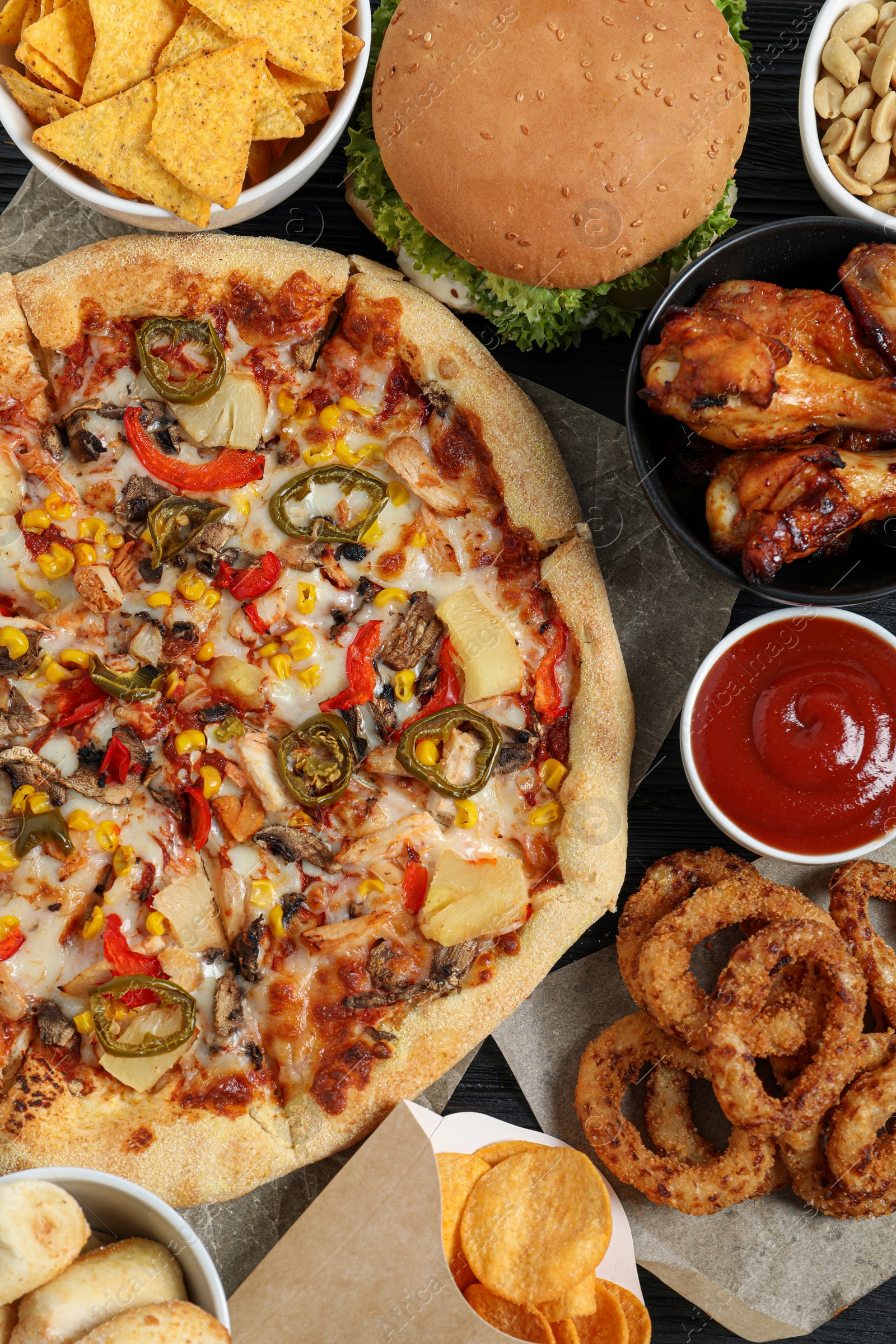 Photo of Pizza, onion rings and other fast food on table, flat lay