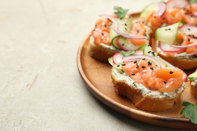 Photo of Tasty canapes with salmon served on light grey table, closeup. Space for text