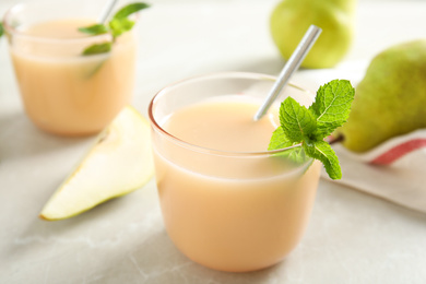 Tasty pear juice with mint on light grey table, closeup