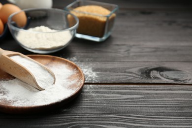 Pate and scoop with baking powder on black wooden table, closeup. Space for text