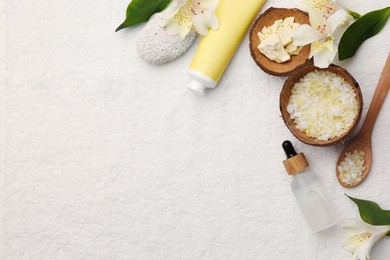 Flat lay composition with spa products and leaves on white towel. Space for text