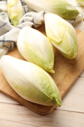 Raw ripe chicories on wooden table, closeup