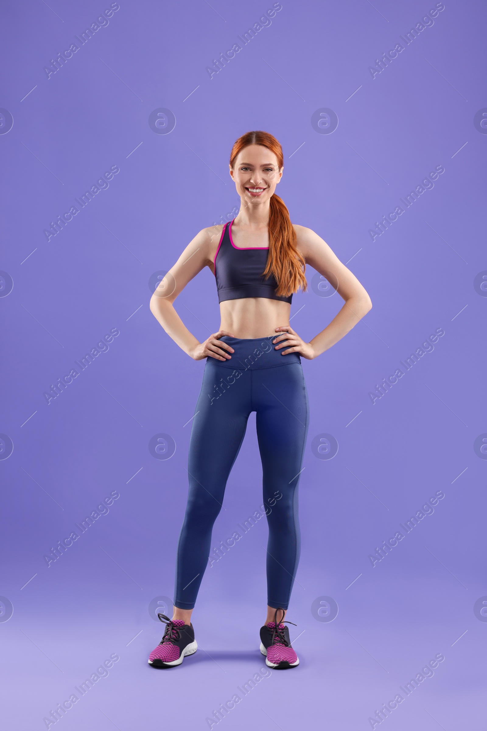 Photo of Young woman wearing sportswear on violet background