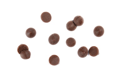 Delicious dark chocolate chips on white background, flat lay