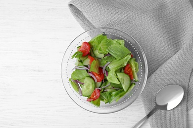 Photo of Bowl of salad with cucumber, lettuce and tomato served on white wooden table, flat lay. Space for text