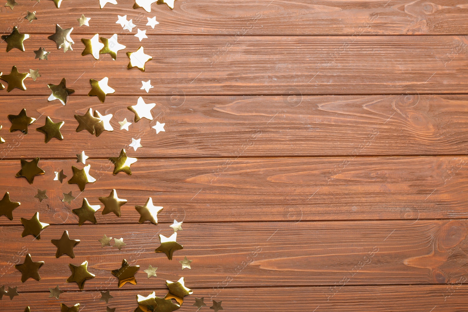 Photo of Confetti stars with space for text on wooden background, top view. Christmas celebration