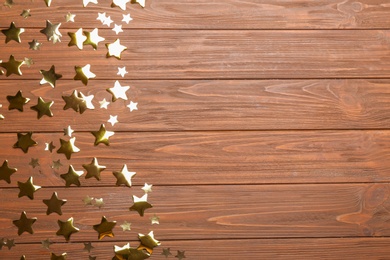 Photo of Confetti stars with space for text on wooden background, top view. Christmas celebration