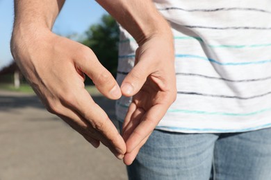 Photo of Gay couple forming heart with hands outdoors, closeup