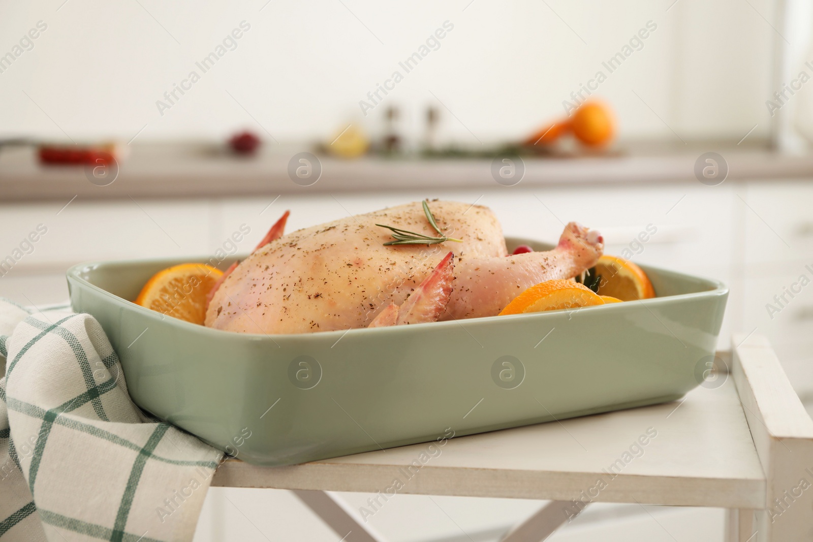 Photo of Chicken with orange slices in baking pan on wooden table