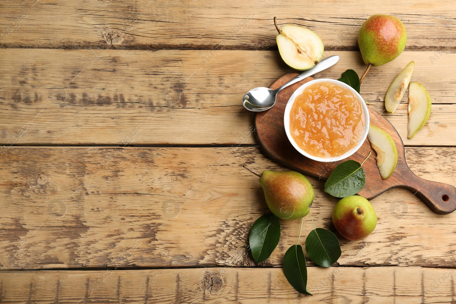 Photo of Delicious pear jam and fresh fruits on wooden table, flat lay. Space for text