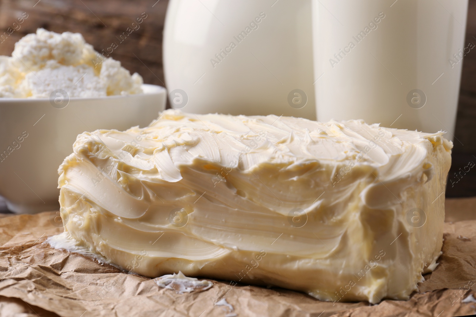 Photo of Tasty homemade butter and dairy products on parchment, closeup