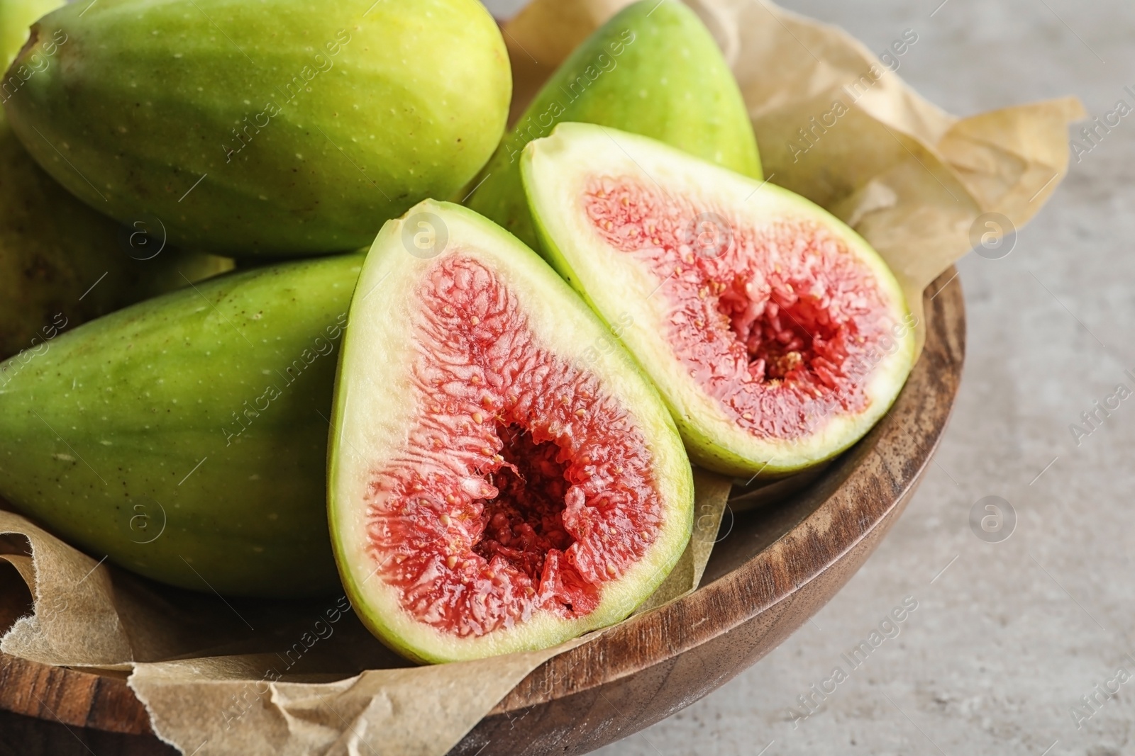 Photo of Bowl with fresh ripe figs on table, closeup