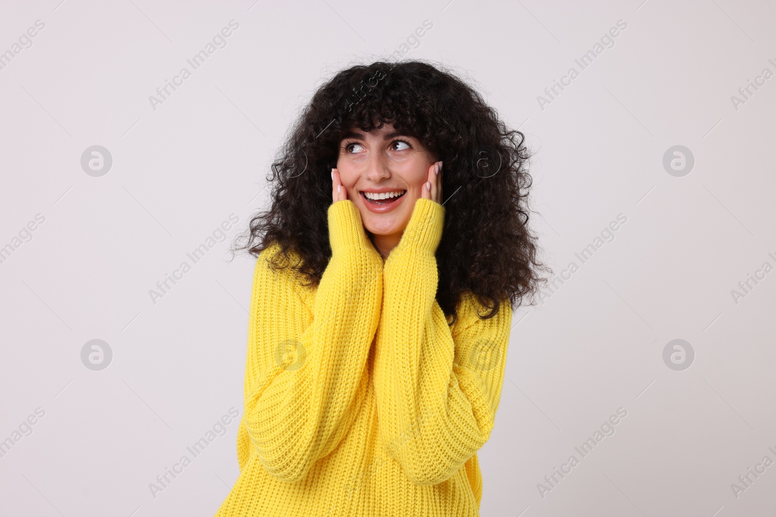 Photo of Happy young woman in stylish yellow sweater on white background