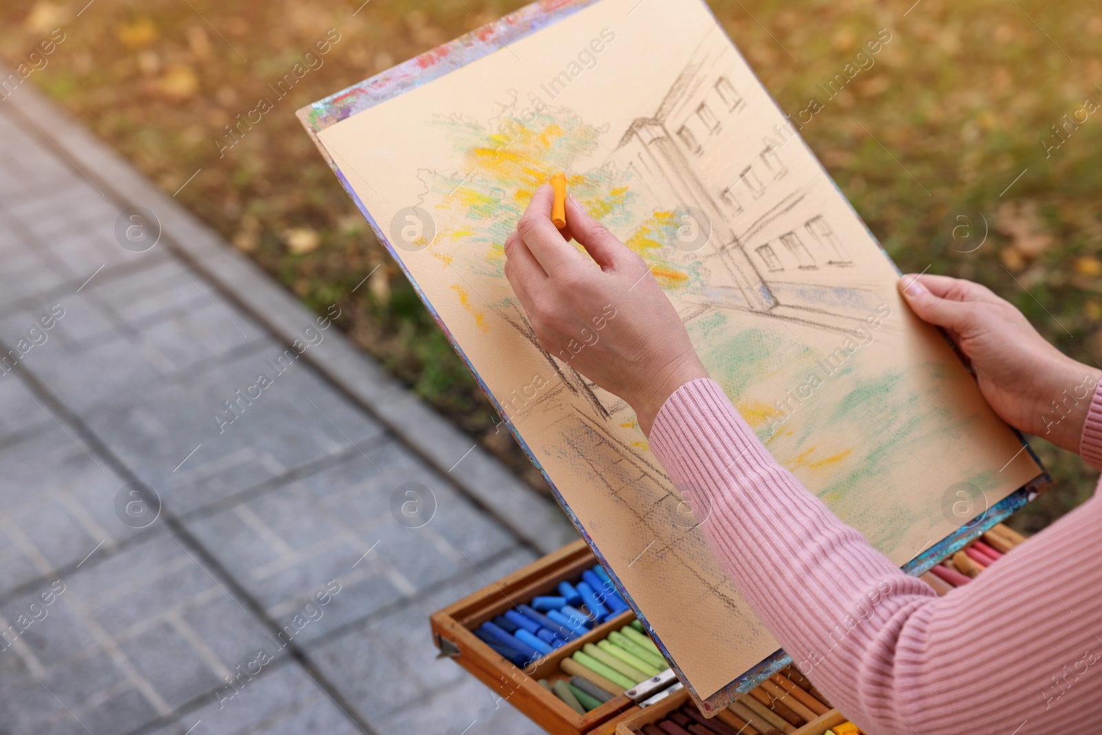 Photo of Woman drawing with soft pastels on street, closeup