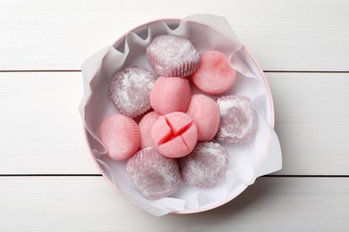 Many different delicious mochi in box on white wooden table, top view. Traditional Japanese dessert