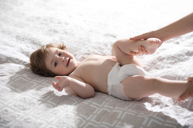 Orthopedist examining cute little baby on bed