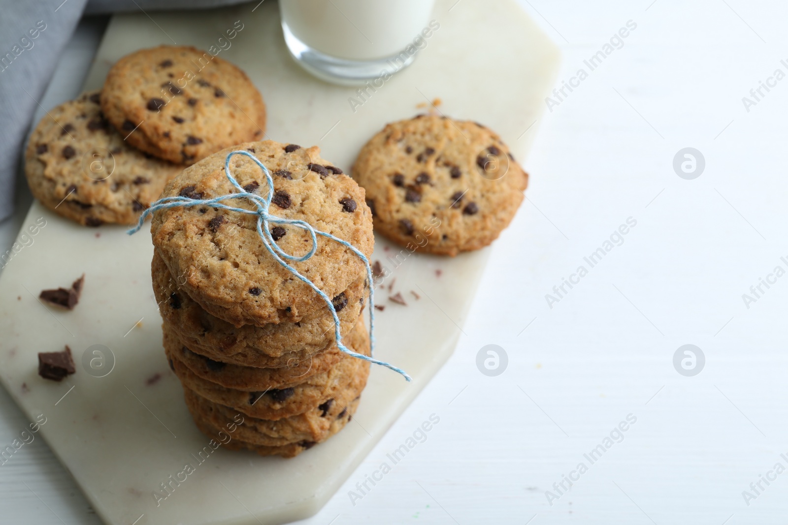 Photo of Tasty chocolate chip cookies on white wooden table, closeup. Space for text