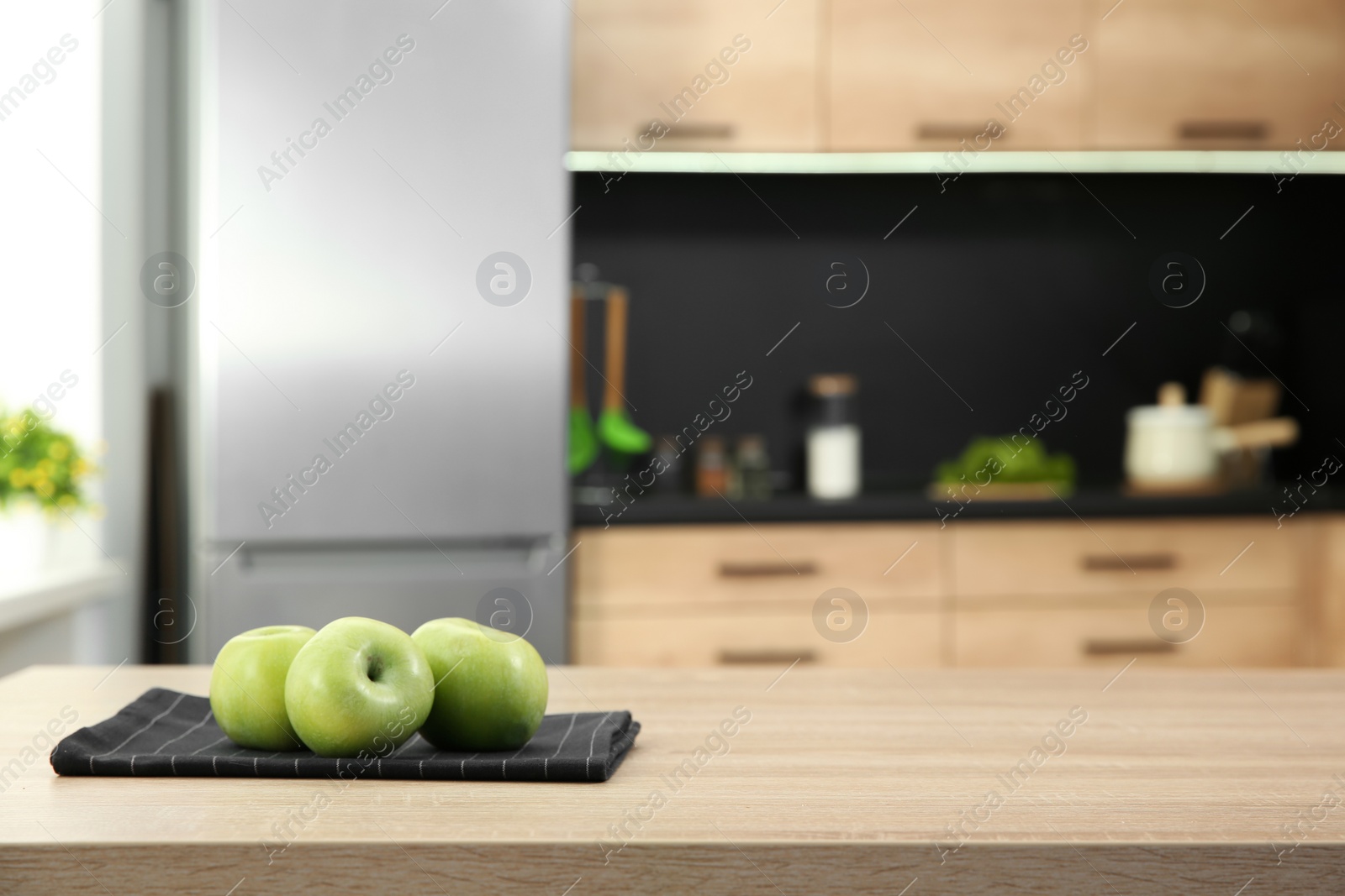 Photo of Fresh apples on table in kitchen, selective focus