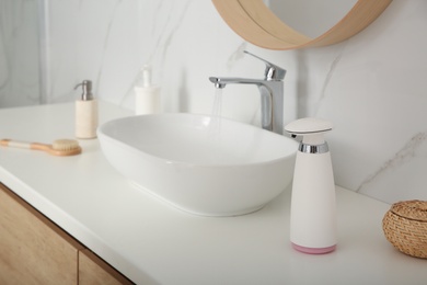 Modern automatic soap dispenser on countertop in bathroom