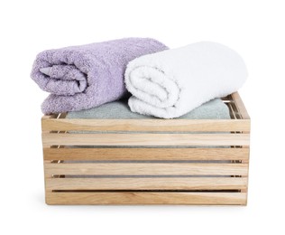 Photo of Rolled soft towels in wooden crate isolated on white