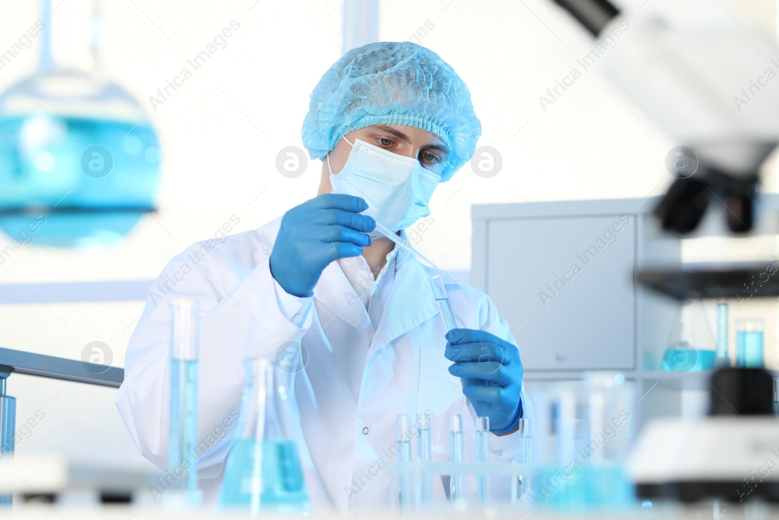 Photo of Scientist dripping sample into test tube in laboratory. Medical research