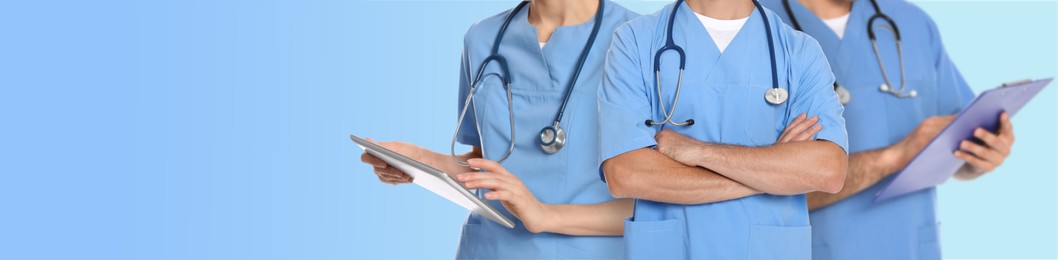 Doctors and nurse on light blue background, closeup. Banner design with space for text
