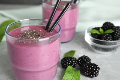 Delicious blackberry smoothie on marble table, closeup. Space for text