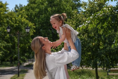 Happy mother with her daughter spending time together in park