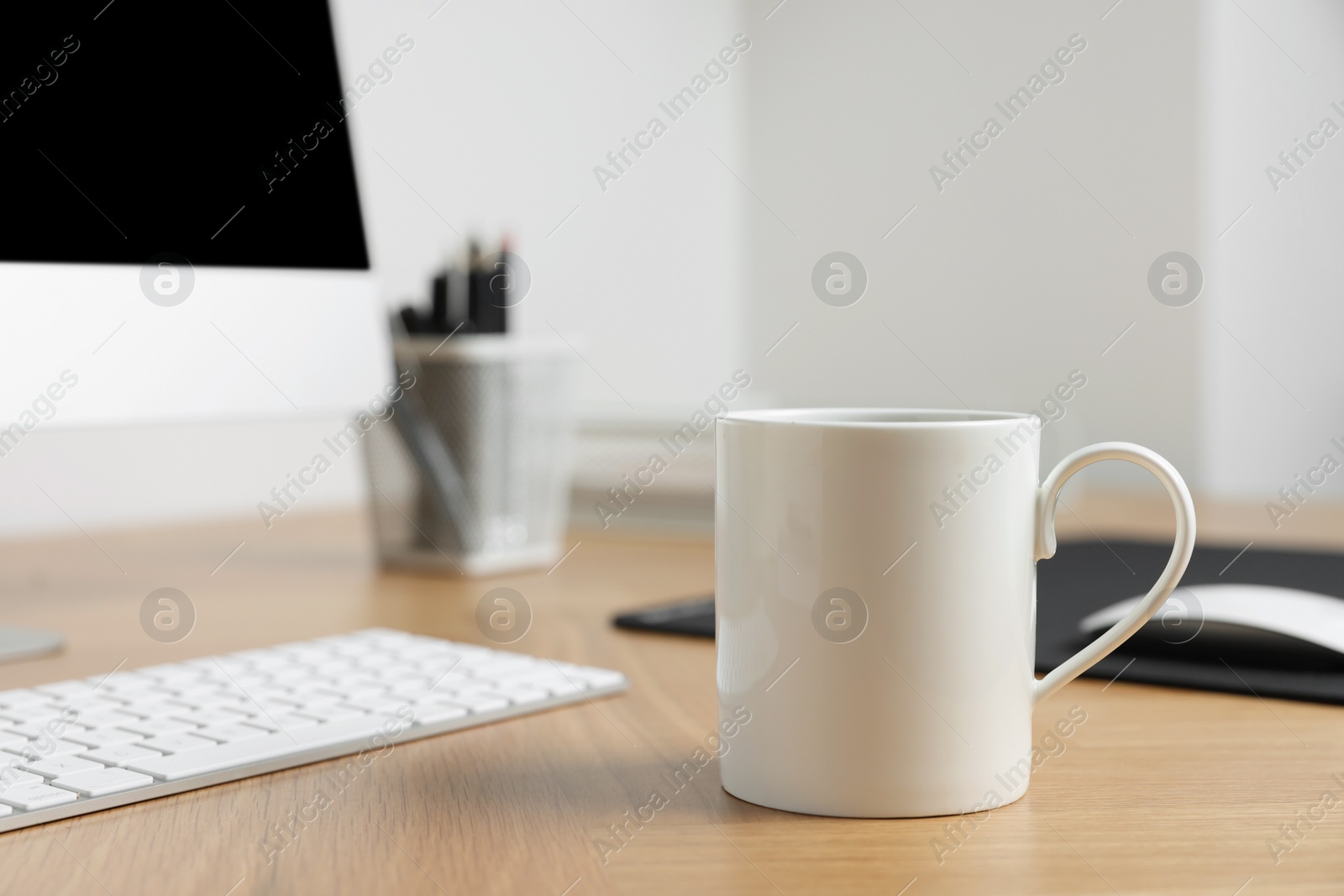 Photo of Blank ceramic mug on wooden table. Mockup for design