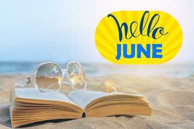 Image of Hello June. Beautiful sunglasses, book and shell on sandy beach