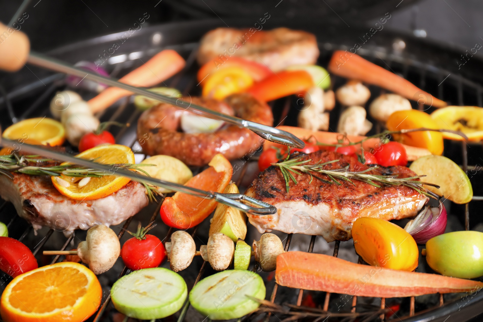 Photo of Cooking delicious meat and vegetables on barbecue grill, closeup