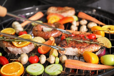 Cooking delicious meat and vegetables on barbecue grill, closeup