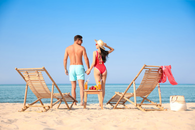 Photo of Couple resting on sunny beach at resort