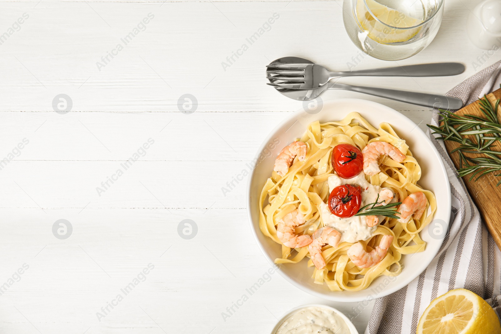 Photo of Delicious pasta with shrimps served on white wooden table, flat lay. Space for text