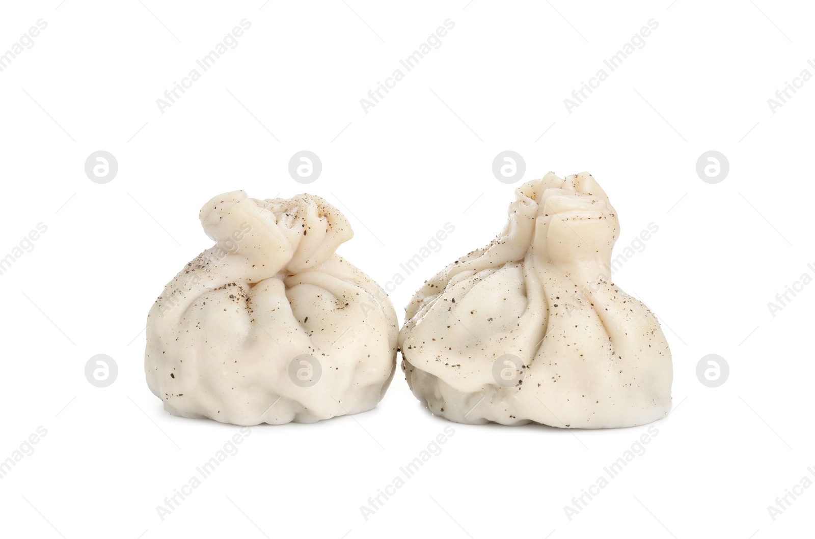 Photo of Two tasty khinkali (dumplings) and spices isolated on white. Georgian cuisine