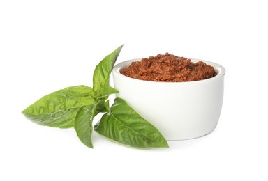 Delicious adjika sauce in bowl and basil isolated on white