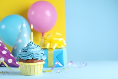 Photo of Delicious birthday cupcake with candle on color background, space for text