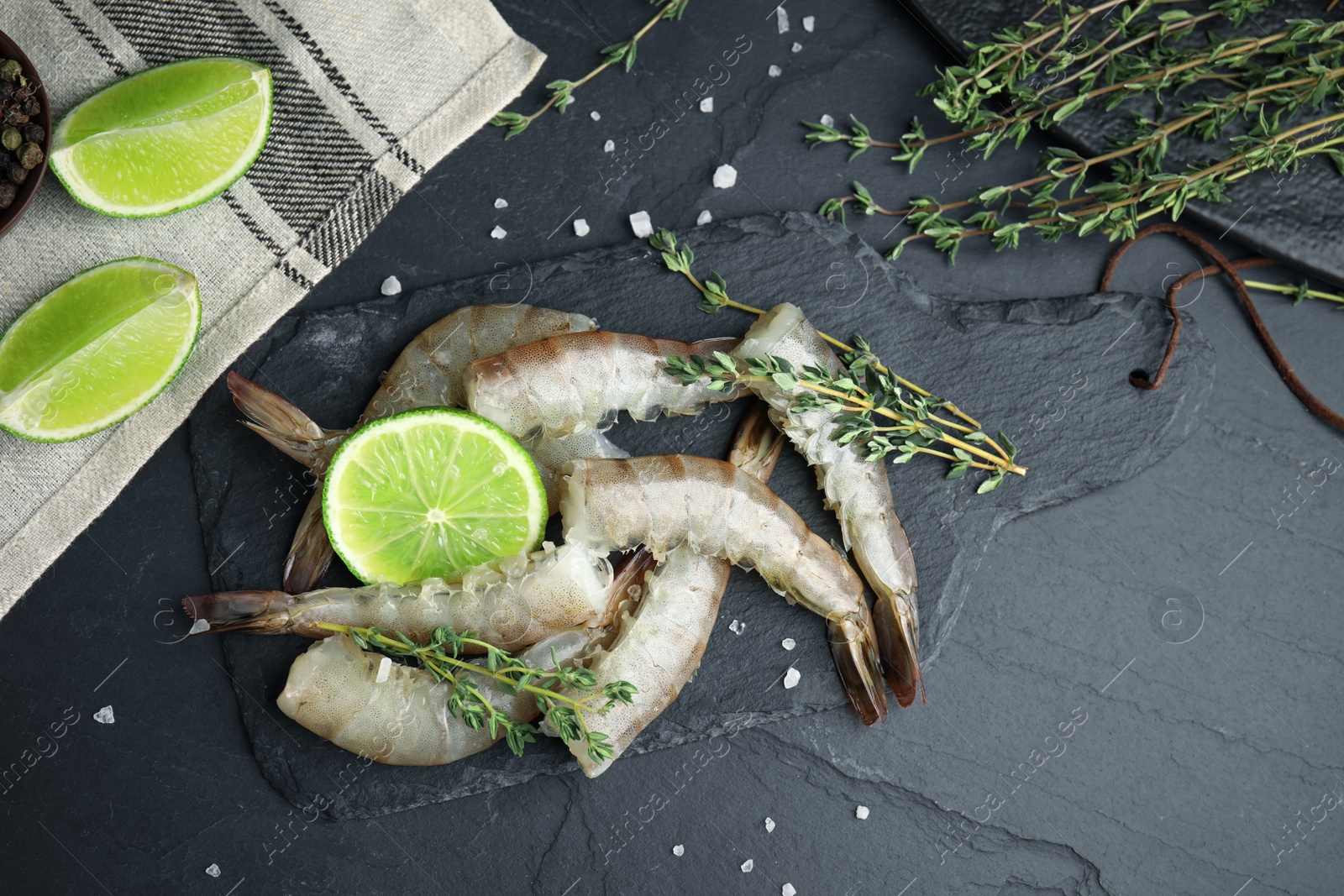 Photo of Flat lay composition with raw shrimps on black table