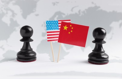 Photo of Chess pieces, American and Chinese flags on world map. Trade war concept
