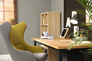 Comfortable workplace with wooden table and armchair