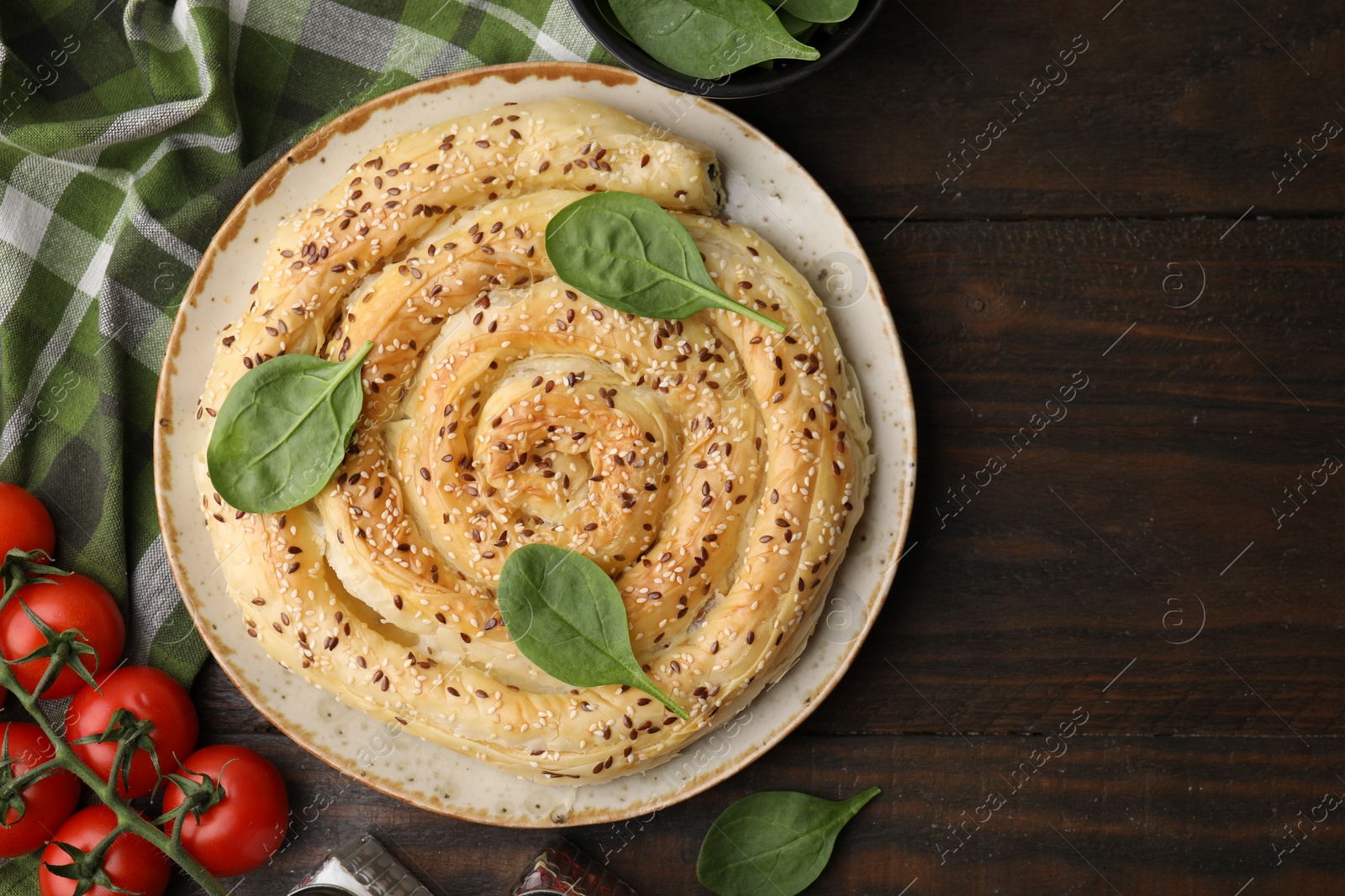 Photo of Delicious puff pastry with spinach on wooden table, flat lay