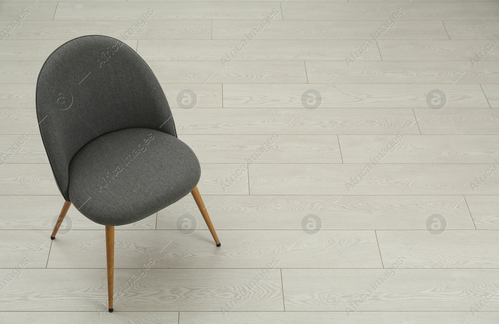 Photo of Stylish grey chair on floor. Space for text