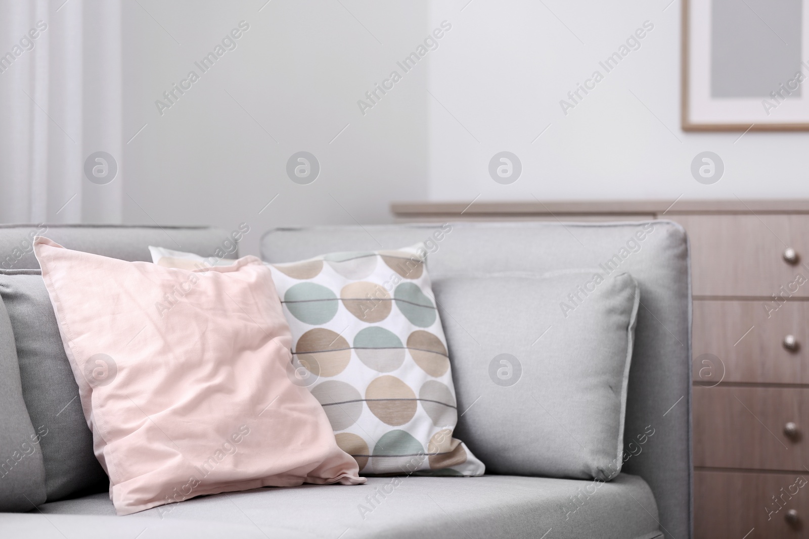Photo of Different soft pillows on sofa in room. Interior element