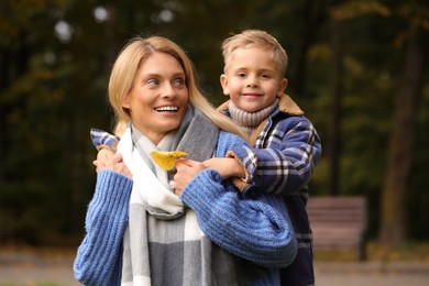 Happy mother with her son in autumn park