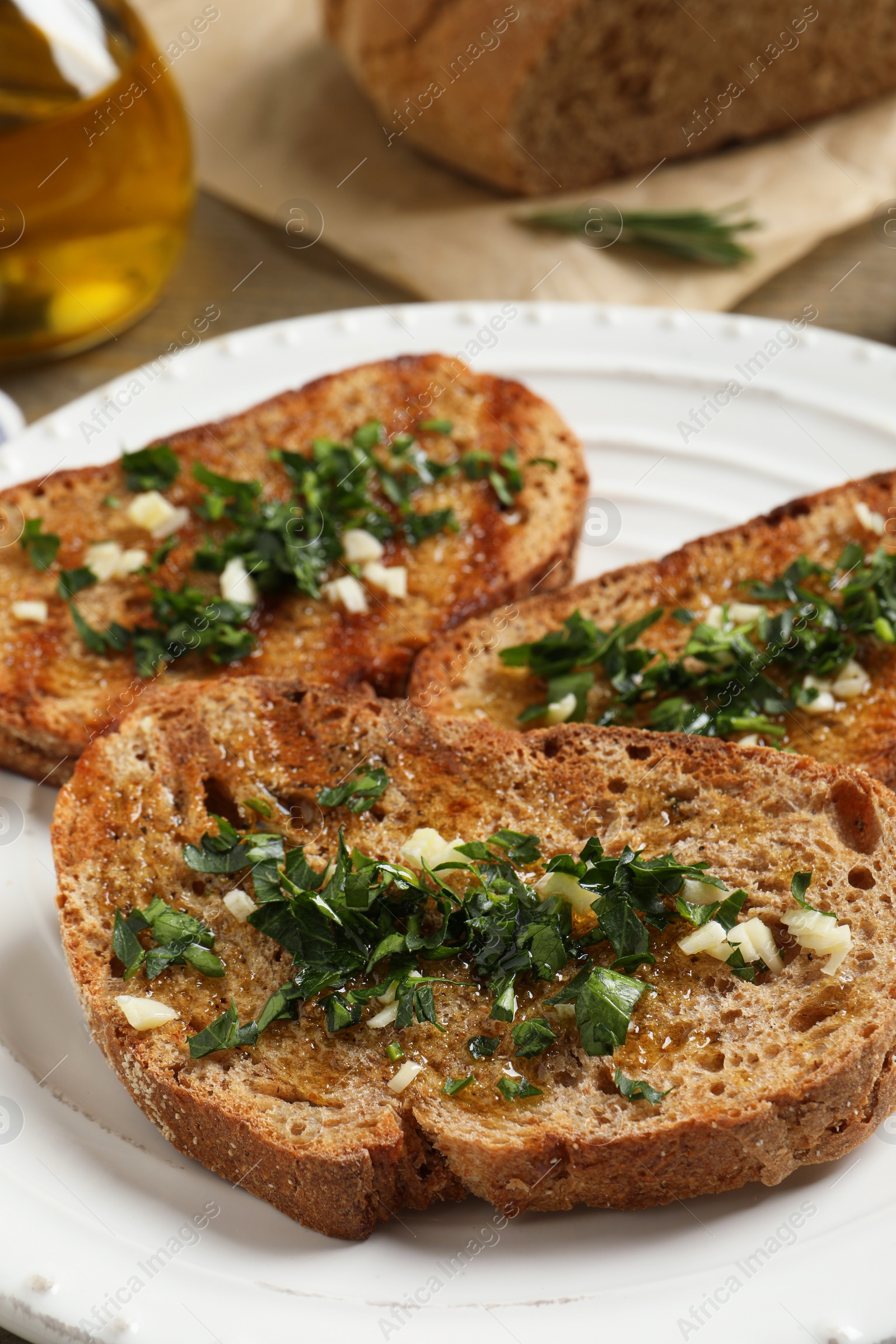 Photo of Tasty bruschettas with oil and garlic on plate, closeup