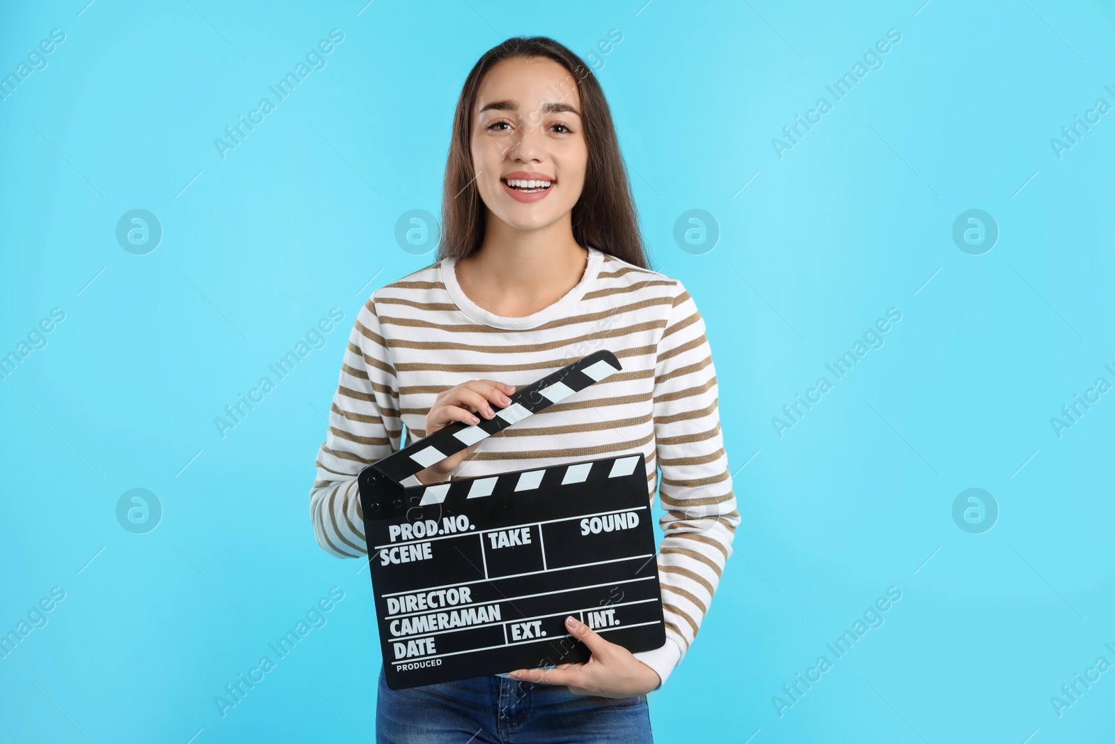 Photo of Woman with clapperboard on color background. Cinema show