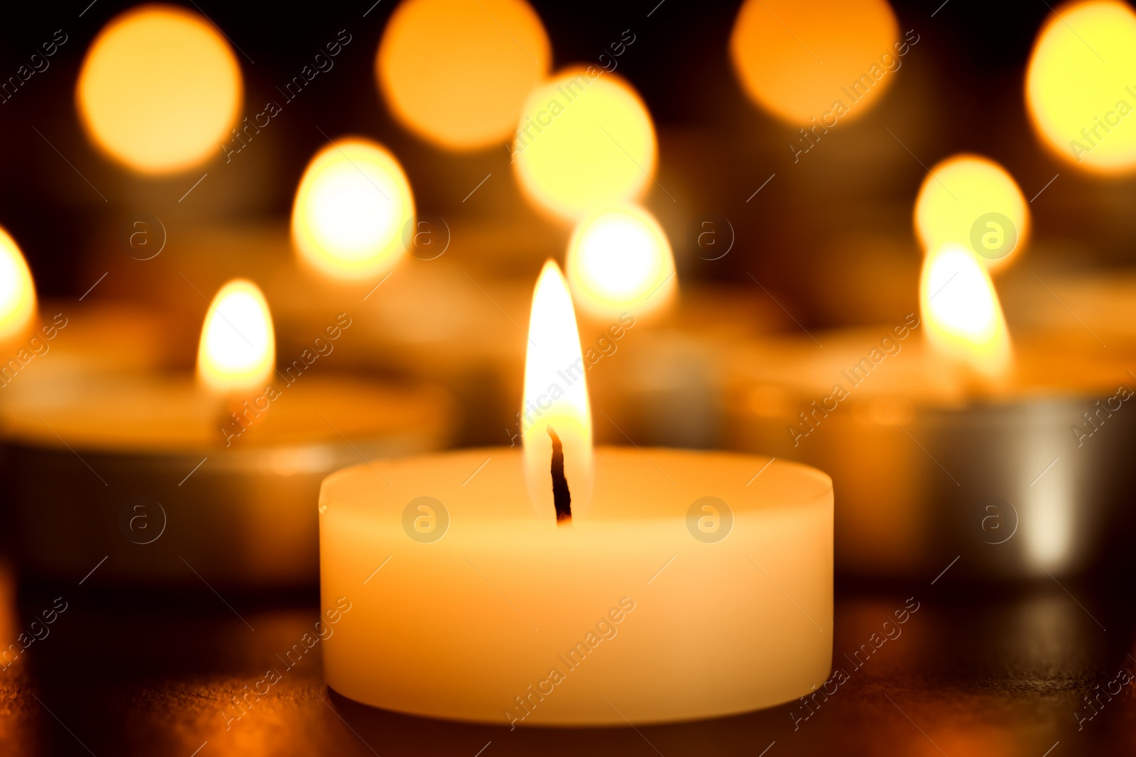 Photo of Burning candle on table, closeup. Funeral symbol